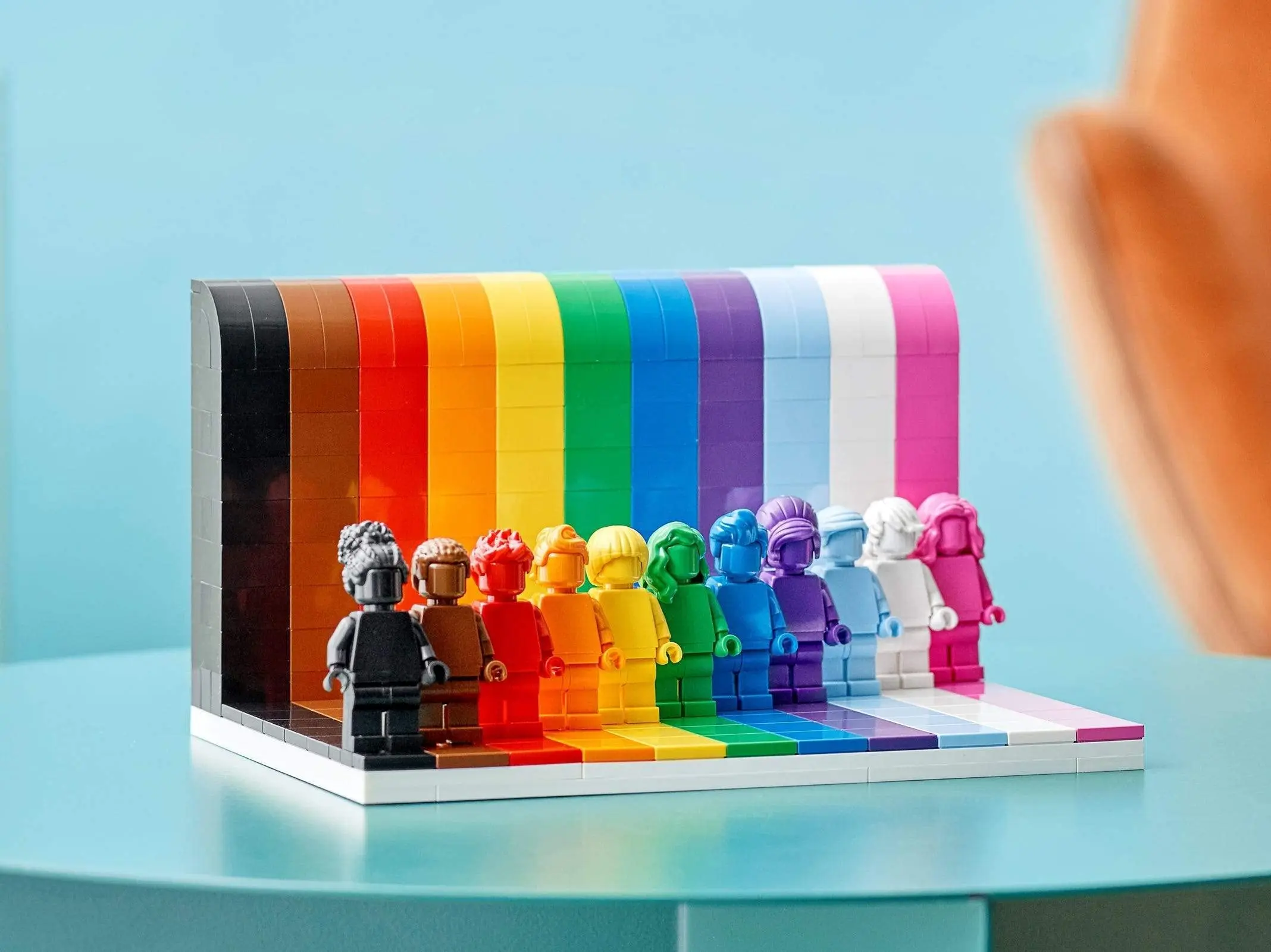 LEGO Everyone Is Awesome 11 Monochrome Minifigures with Color Hairstyle Against A Background of Corresponding Rainbow Stripes