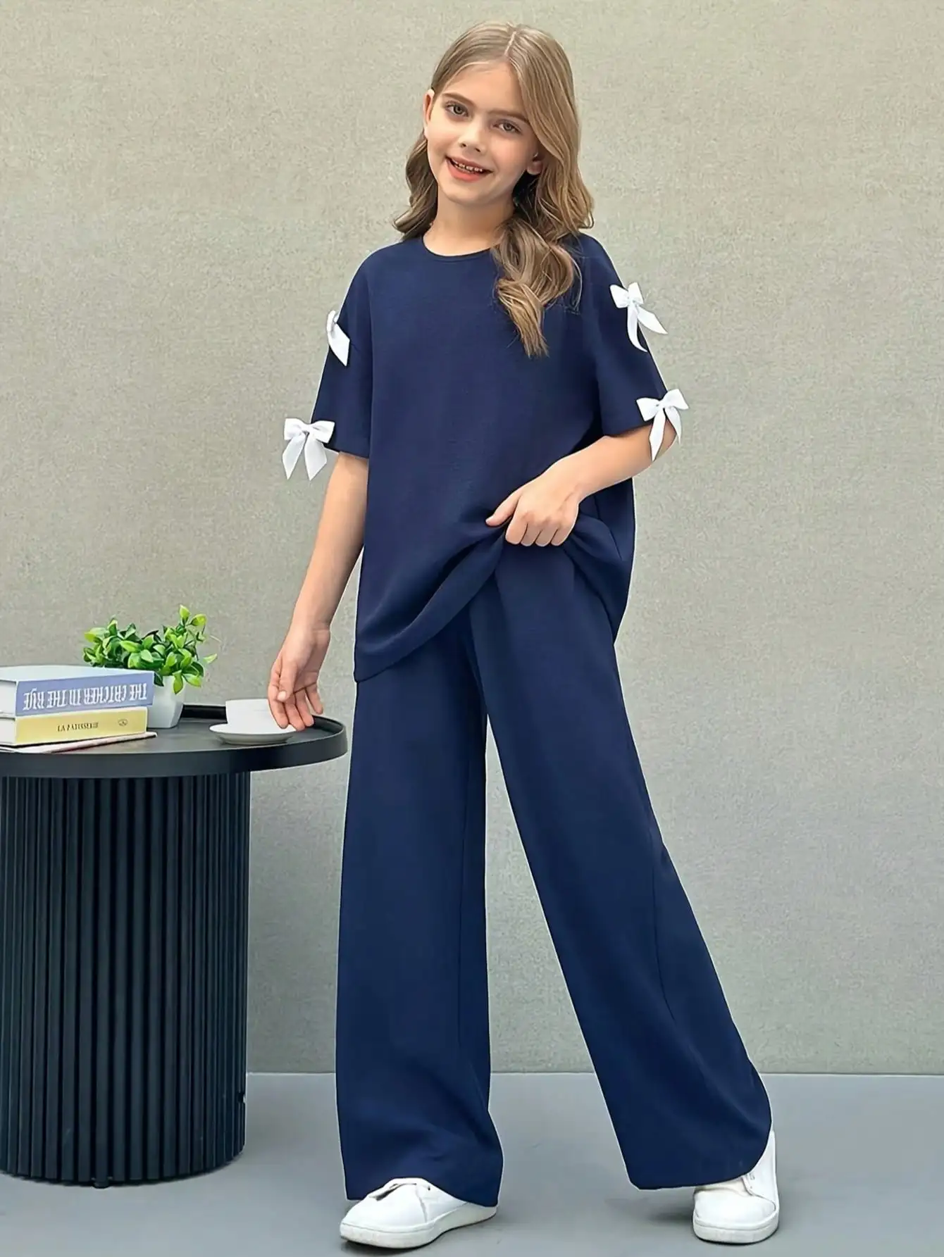 Conjunto de duas peças para meninas: camiseta casual moderna com gola redonda, laço e decoração 3D, solta e de cor sólida, e calça de perna reta.