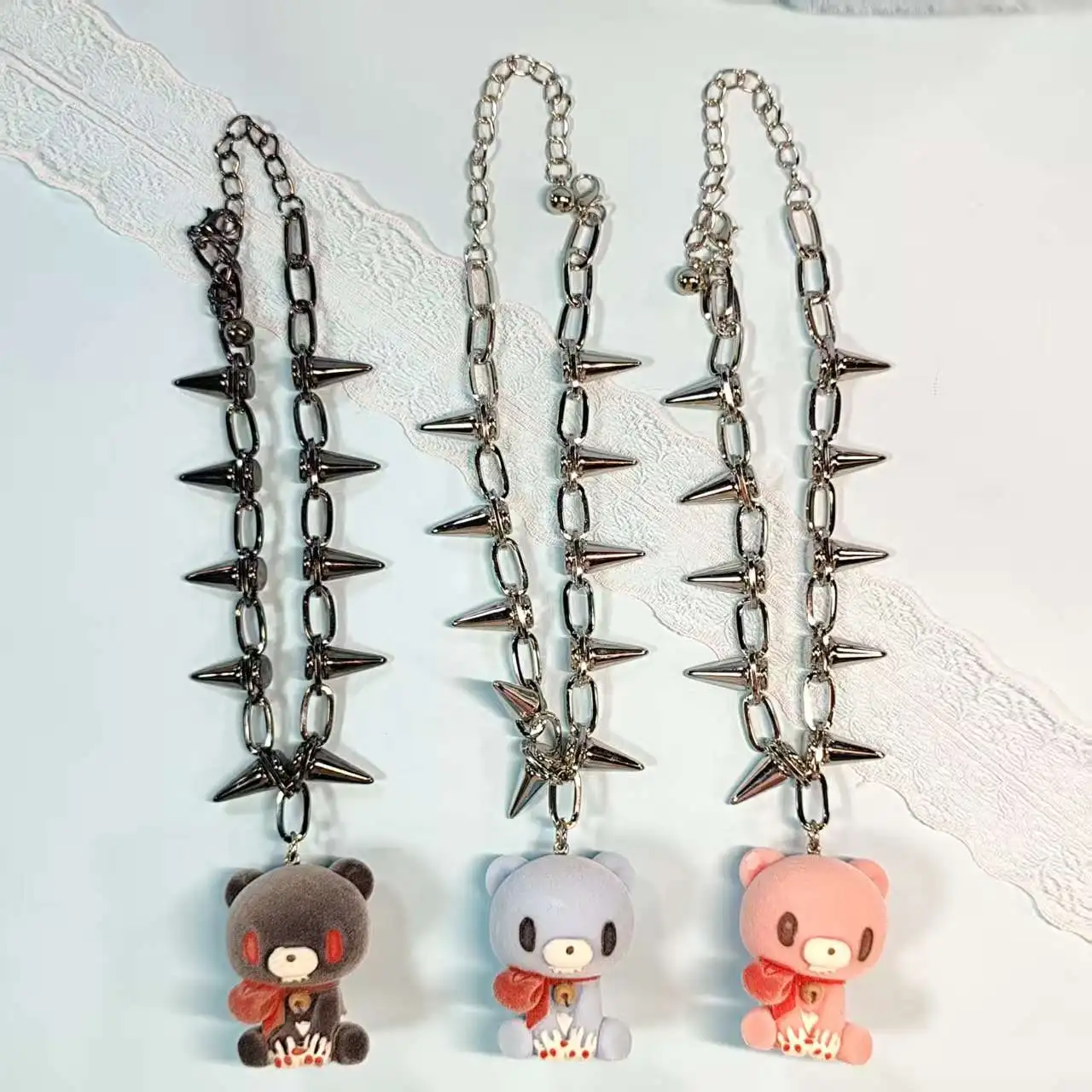Three necklaces with spiked chains and cute bear pendants in gray, blue, pink. Edgy yet adorable accessories.