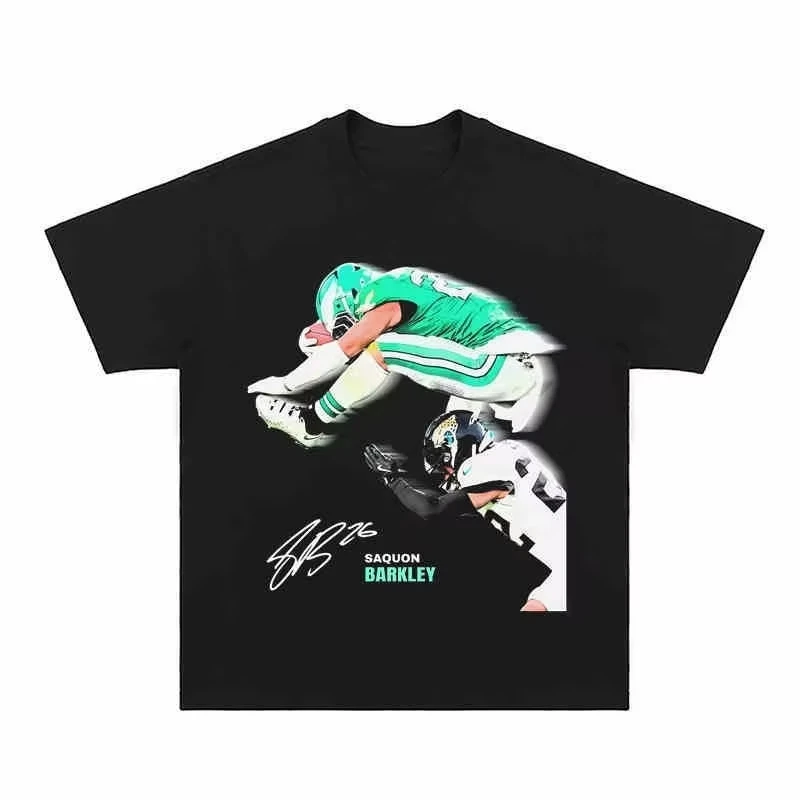 2025 Moda para todas las estaciones Mujeres y hombres Una camiseta americana de manga corta con una escena voladora de Saquo Barkley en el fútbol NFL