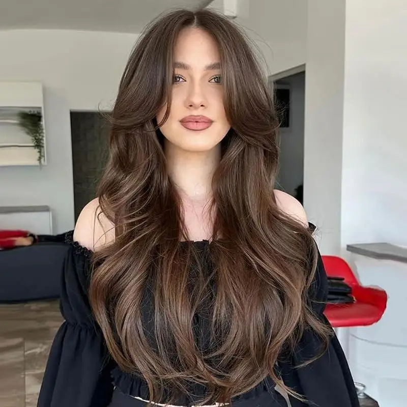 女性向けのヘアスタイル。手編みで作られた、金色のウェーブとレイヤー状のカールが特徴の、長い巻き毛。前髪はカーテンのように広がるスタイル。
