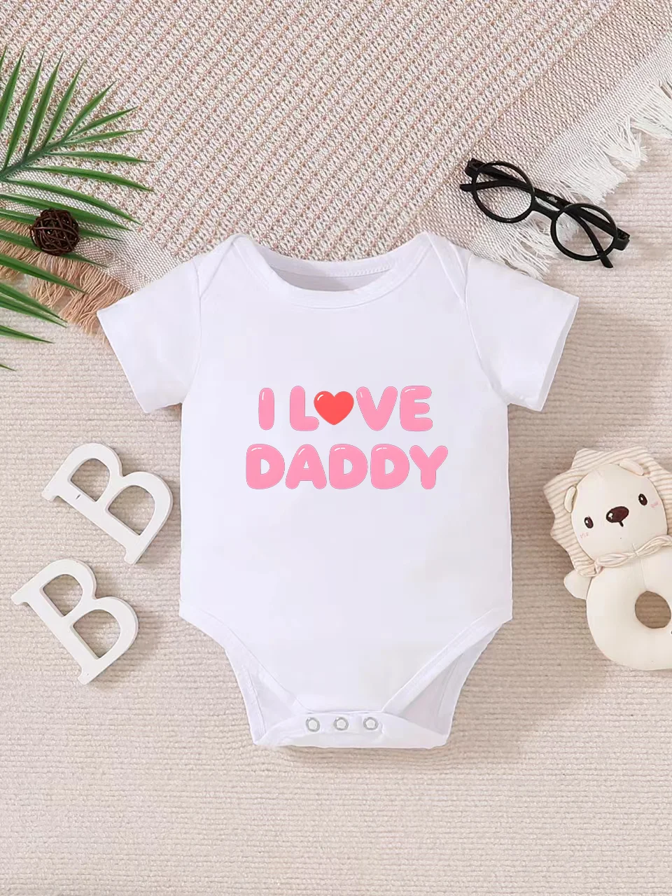 Playful letter-printed baby short-sleeve triangle bodysuit. Button closure for easy dressing