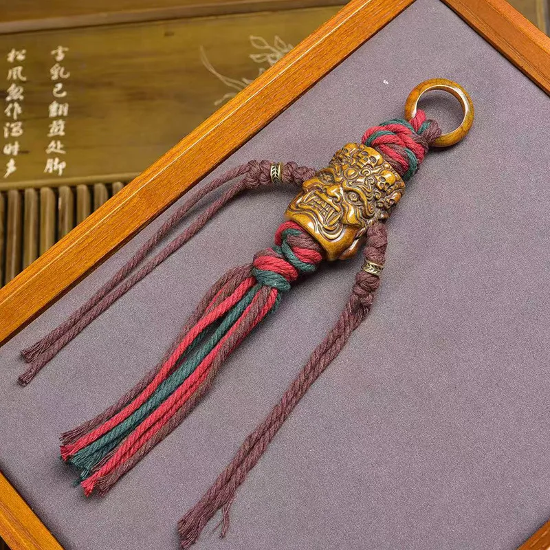 

Hand-woven rope pendant with Tibetan-style bone carving of Mahakala devouring a demon, crafted by hand.