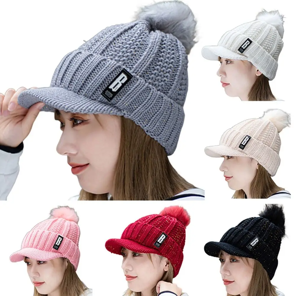 قبعة محبوكة عصرية دافئة سميكة مع كرات فرو قبعة شتوية مقاومة للرياح لحماية الأذن للنساء
