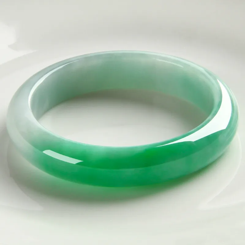 Natural Burmese ice jadeite bracelet with floating patterns, featuring a light to pale green color, a round shape, a