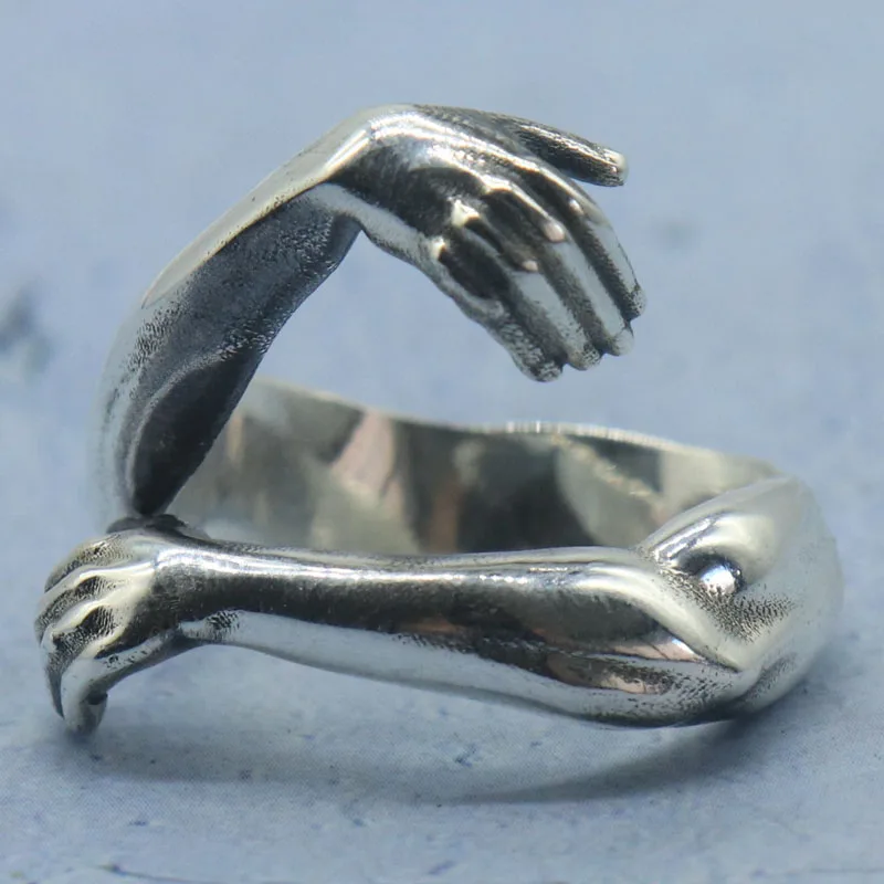 

9,5 г 3D Eternal Embrace имеет деликатно переплетенные руки, обнимающие кольца на палец, индивидуальное твердое серебро 925 пробы, 6-11