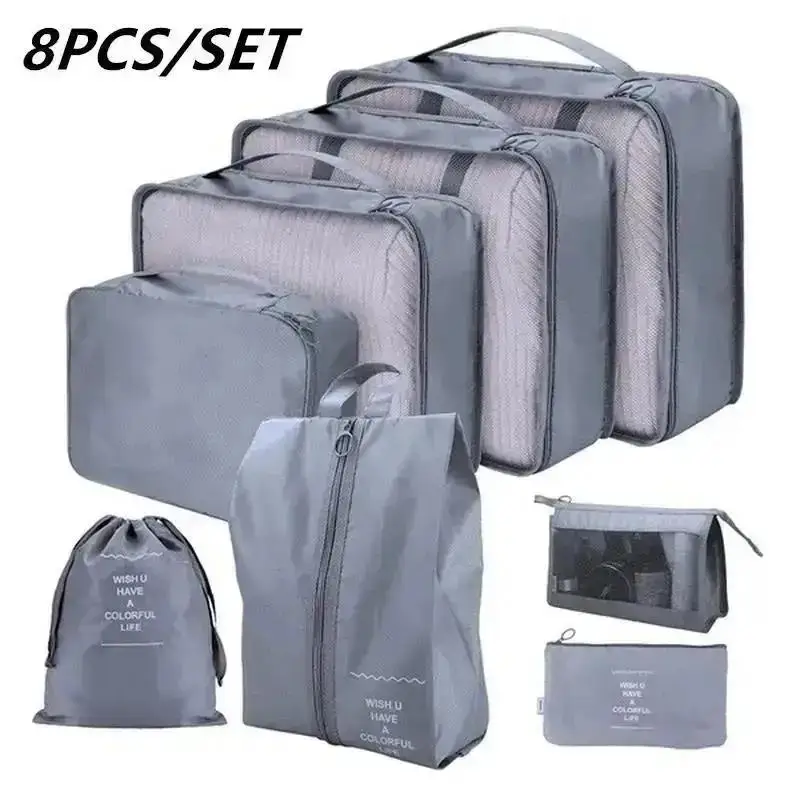 Set of packing cubes and travel organizer bags arranged with clothes and travel items