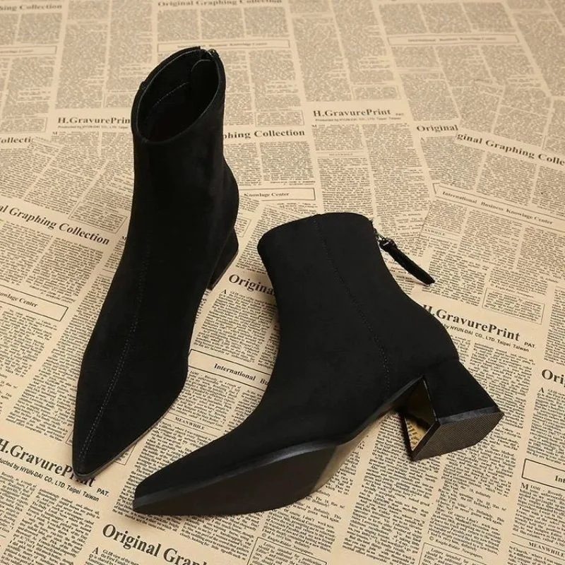 Bottines noires en daim à bout pointu, avec talon épais, fermeture éclair à l’arrière, coupe ajustée, idéales pour l’automne et l’hiver.