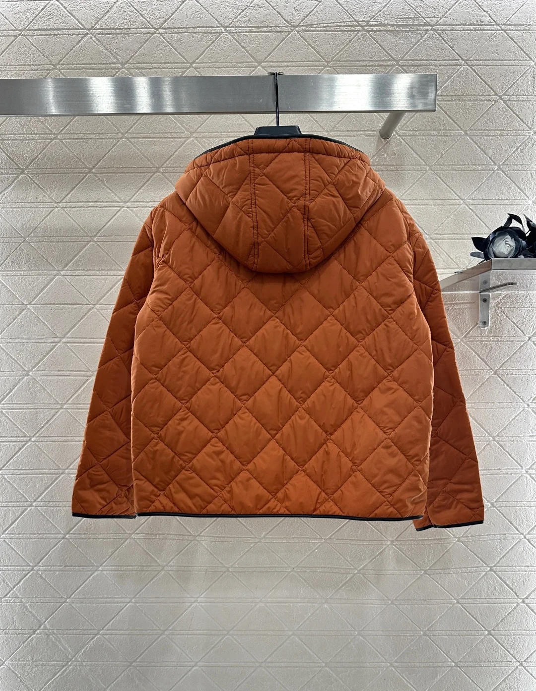 

The orange diamond-patterned hooded jacket with leather pockets and a short hooded cotton-padded jacket is elegant