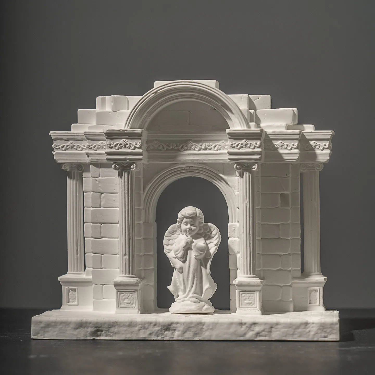 European-style retro gate with Roman columns, cement/plaster decorative art pieces (including little cherubs).