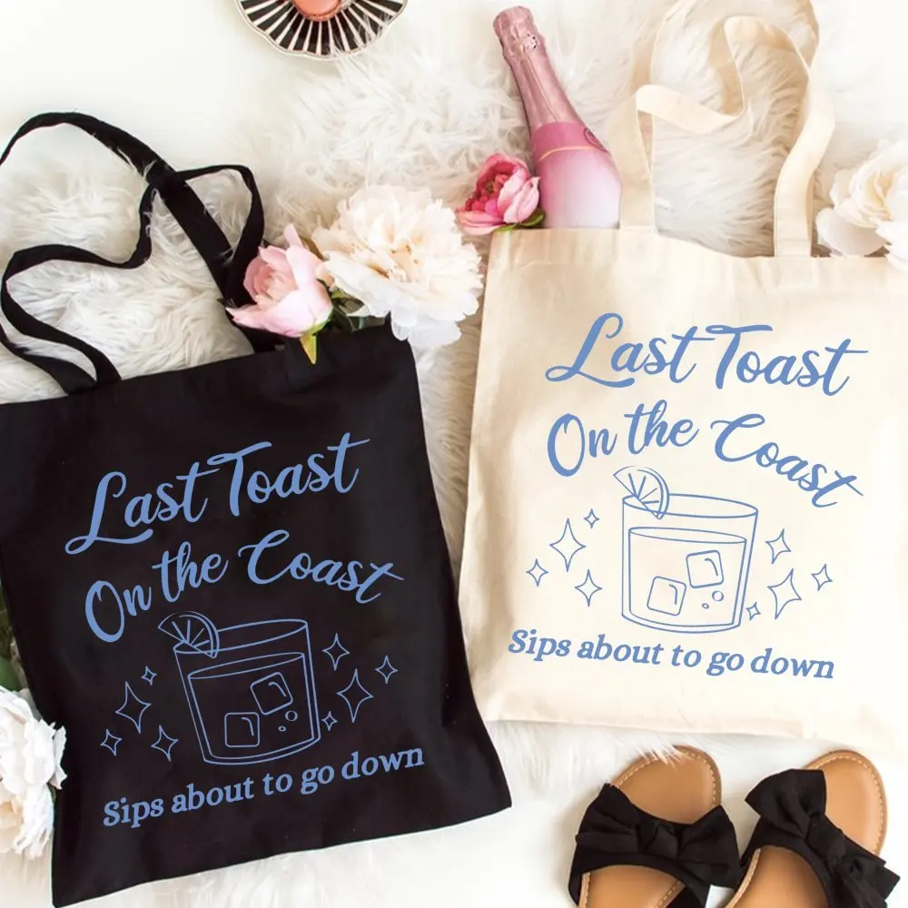 Sommerliche Strand-Tragetasche aus Segeltuch mit „Last Toast On The Coast“-Grafik – Shopper-Tasche mit „Sips About To Go Down“-Motiv für den Küsturlaub – Reisehandtasche