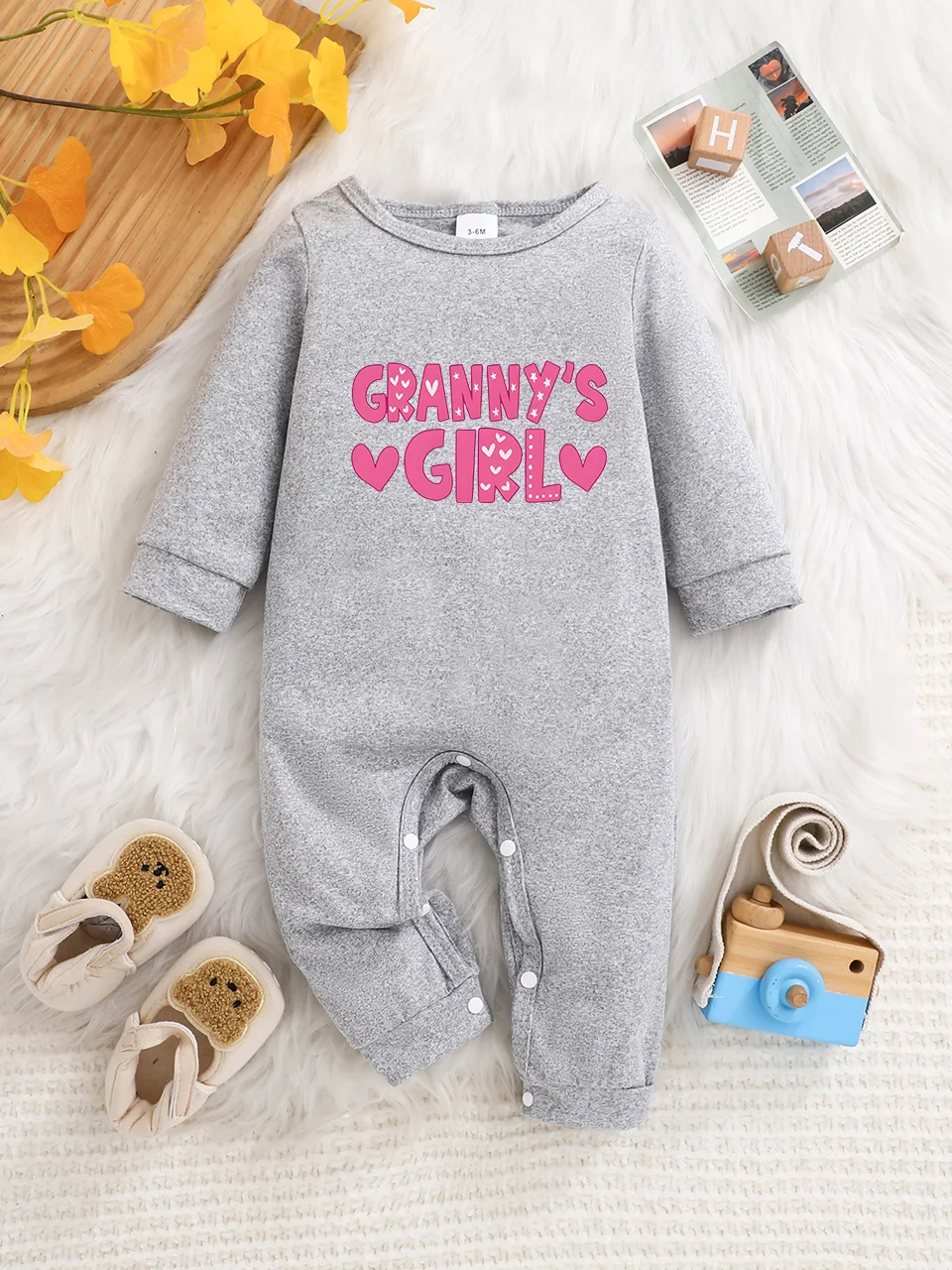 A baby long-sleeved onesie with interesting letter prints. It features a buttoned design for easy putting on and taking off