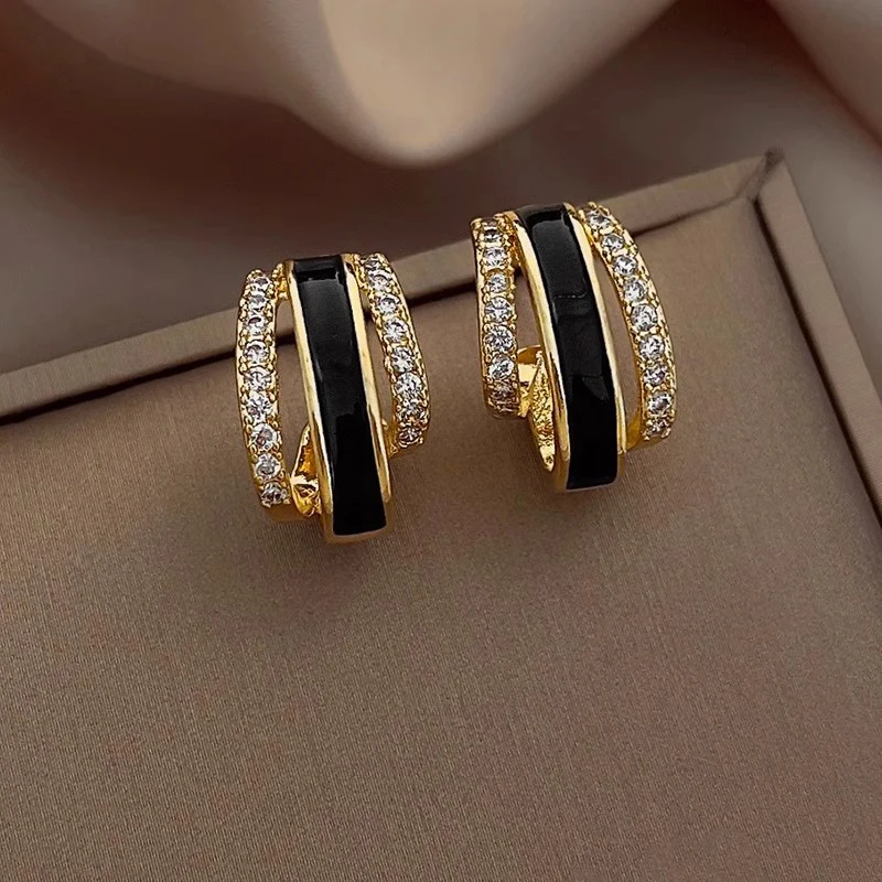 Huitan Trendige goldfarbene, klauenförmige Ohrstecker für Damen, temperamentvolle schwarze Emaille-Ohrringe mit glänzendem CZ-Statement-Schmuck