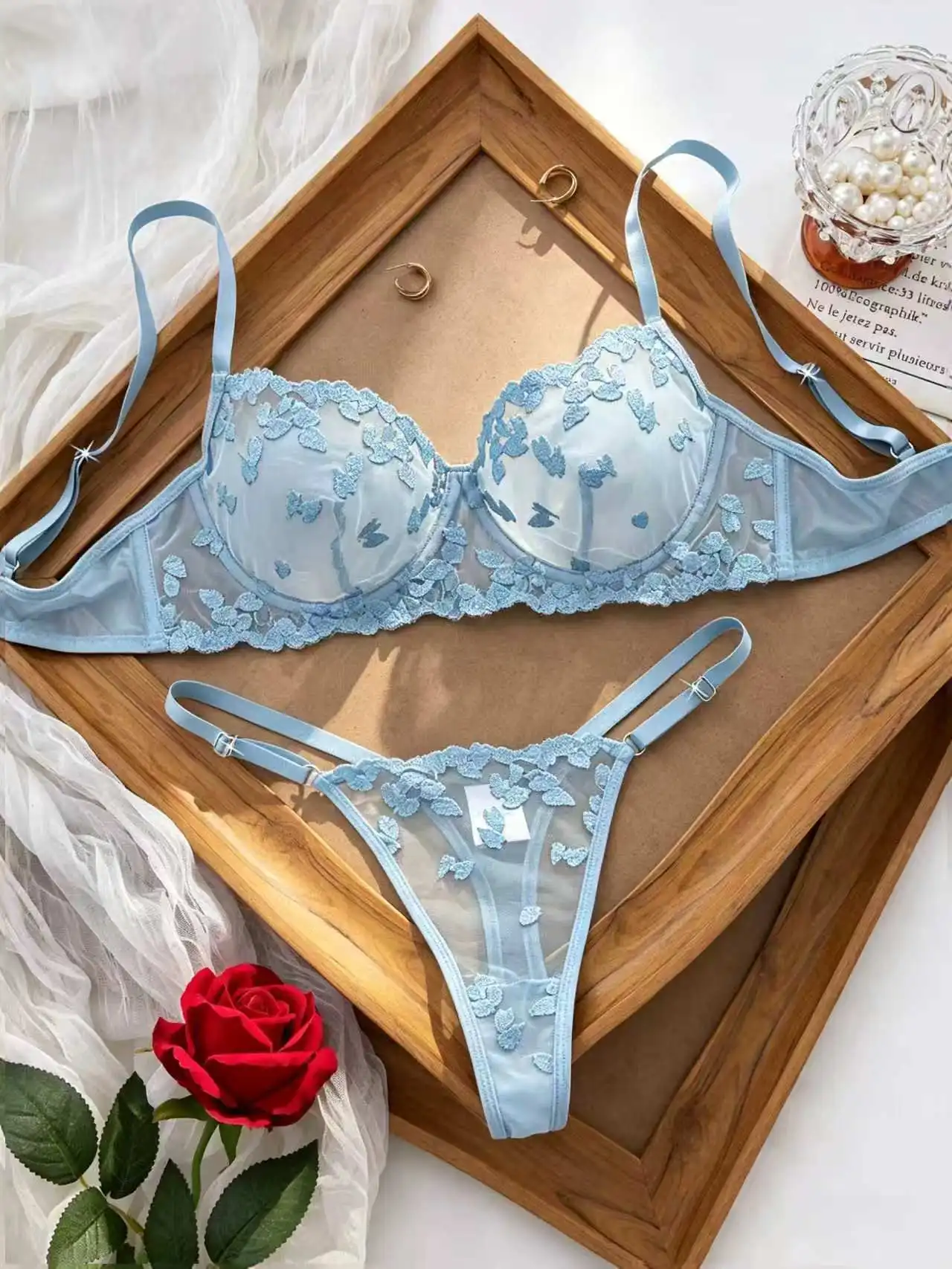 Close-up of floral embroidery with sheer mesh texture and lace trim