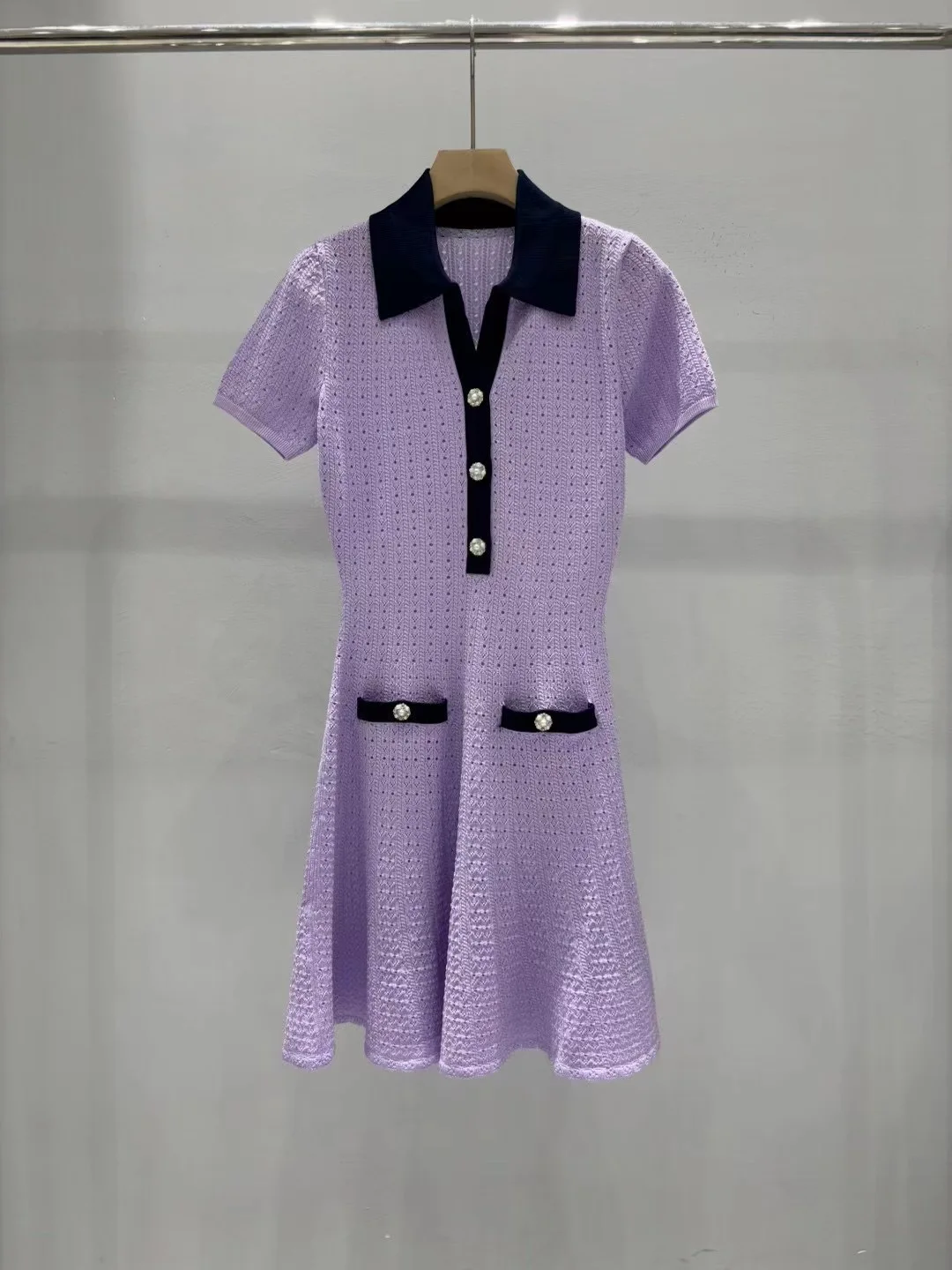 Ein neues lilafarbenes, farbblockierendes, kurzärmliges Strickkleid mit Revers, Ausschnitt und Taille für den Sommer 2025