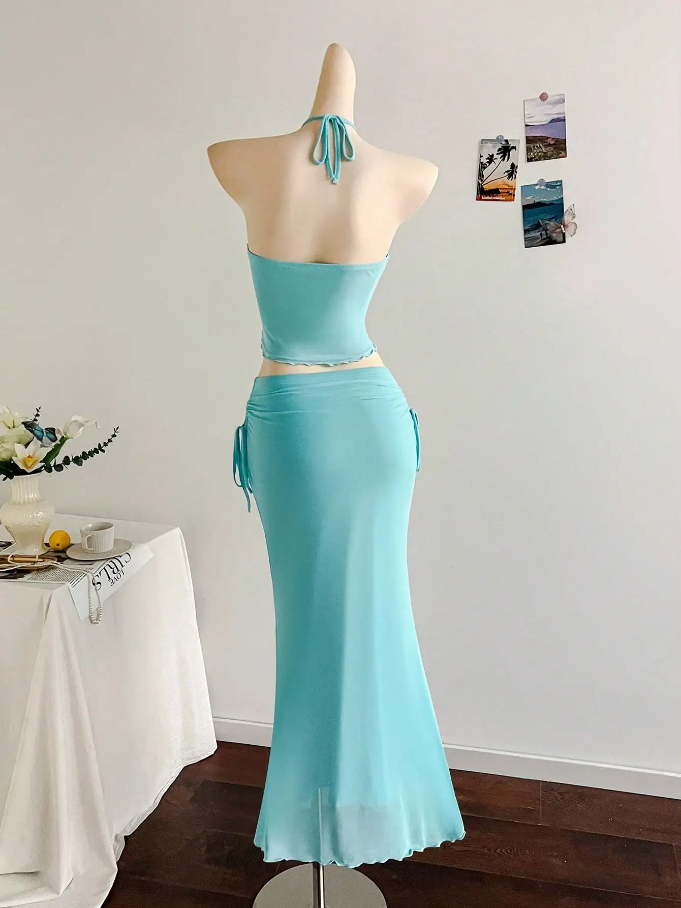 

Аквамариновый комплект из двух предметов: топ-халтер с вырезами и макси-юбка с рюшами, пляжное платье в богемном стиле