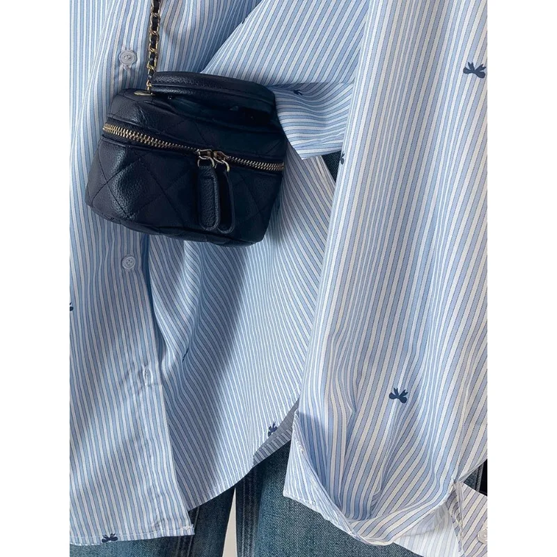 เสื้อเชิ้ตลายทางสีฟ้า เสื้อเชิ้ตแขนยาวพิมพ์ลายโบว์สไตล์เกาหลีลำลองสำหรับผู้หญิง