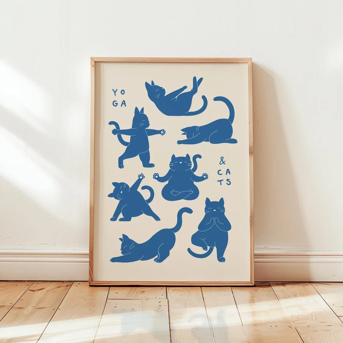 Playful Yoga Cats Wall Art - Calming Print Celebrating Feline Flexibility. The Soft Beige Backdrop and Bold Blue Silhouettes Cre