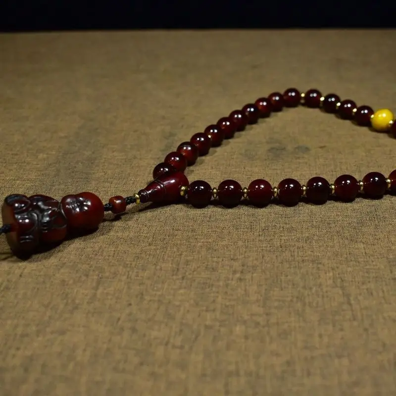 Tibetan-style beads paired with a horn boy figure holding them   Weighs 102 grams