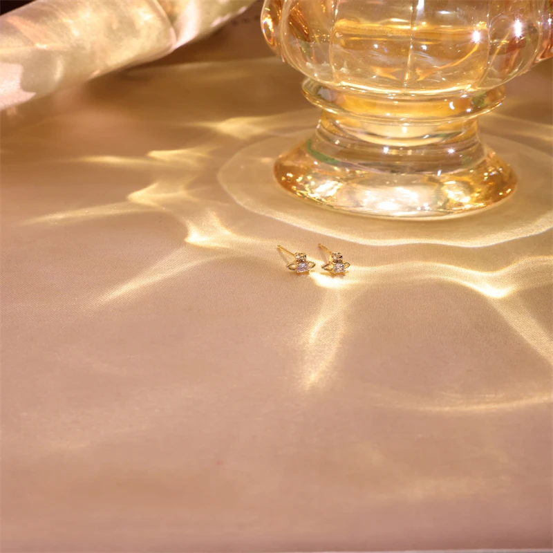 1-زوج من أقراط الزركون الاصطناعية المحيطة بالزحل، أظافر رائعة ولطيفة على شكل عظمة الأذن للنساء، تصميم فريد وبسيط