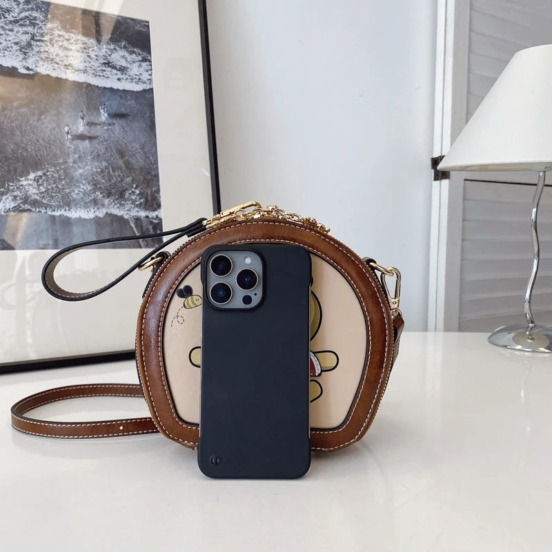 2025 بولي Leather حقيبة يد جلدية صغيرة شكل دائري حقيبة كتف الكرتون الطباعة حقيبة كروس الجسم العلامة التجارية تصميم حقيبة مقبض قصير للنساء