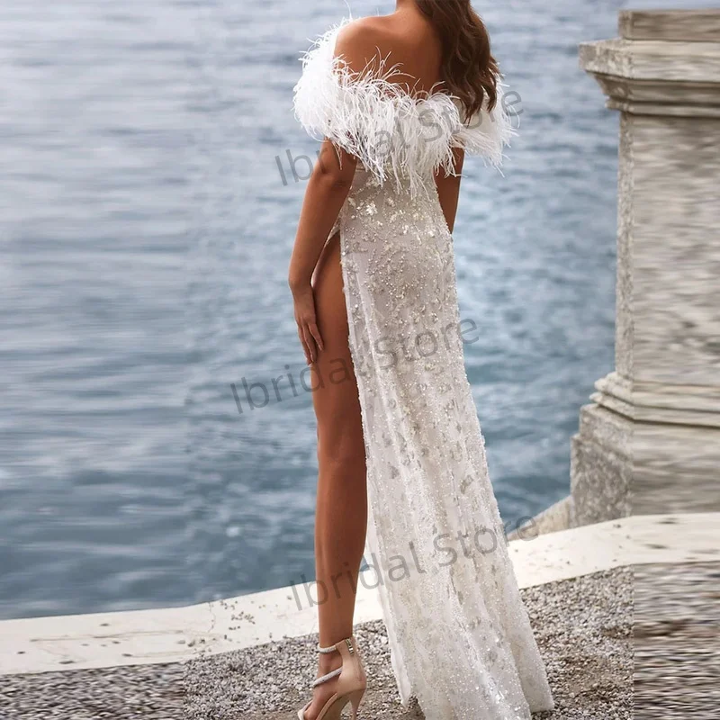 Maßgeschneiderte Abendkleider mit glitzernden Pailletten und langen Ärmeln und Federdetails. Sexy Kleid mit Seitenschlitz