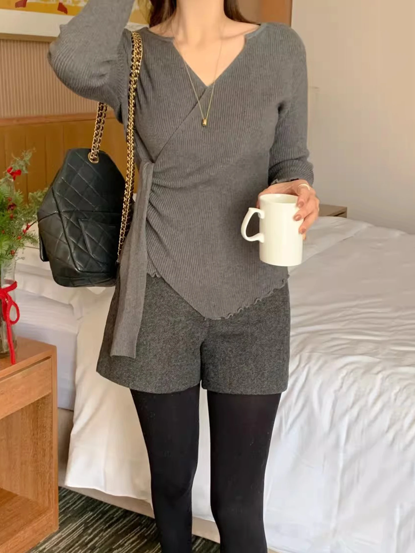 เสื้อสเวตเตอร์ถักคอวีไขว้สำหรับผู้หญิง ทรงเข้ารูป ใส่เป็นเสื้อตัวในได้ เหมาะสำหรับฤดูใบไม้ร่วงและฤดูหนาว เนื้อผ้านุ่มสบาย ดีไซน์ทันสมัย พร้อมดีเทลผูกโบว์ที่คอเสื้อ