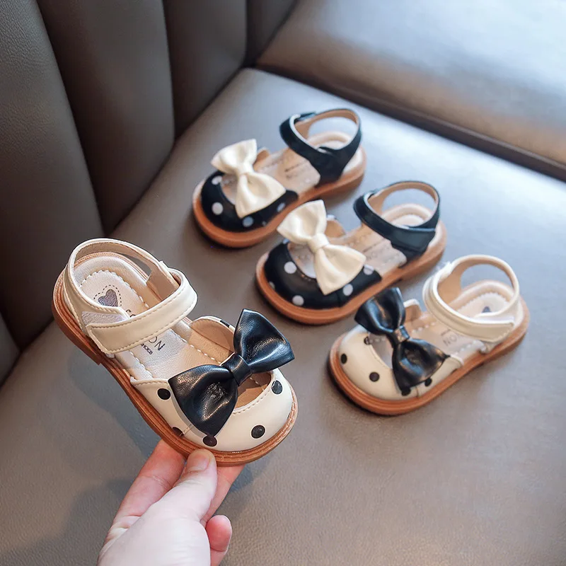 Sandalias de cuero para bebé y niña, zapatos de verano para niños pequeños con cubierta de dedo, sandalias de playa con puntos y pajarita de princesa