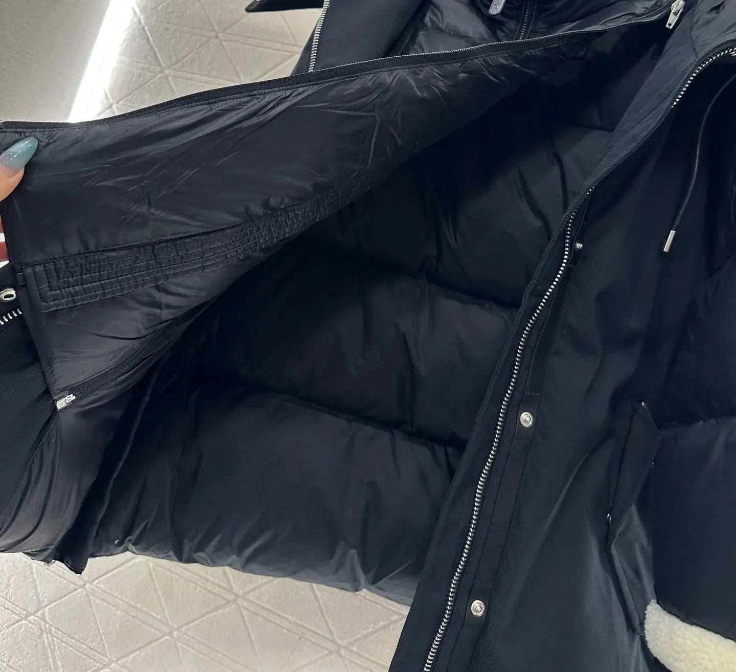 For autumn and winter women's clothing, two black and white contrasting woolen collar hooded down jackets can be split