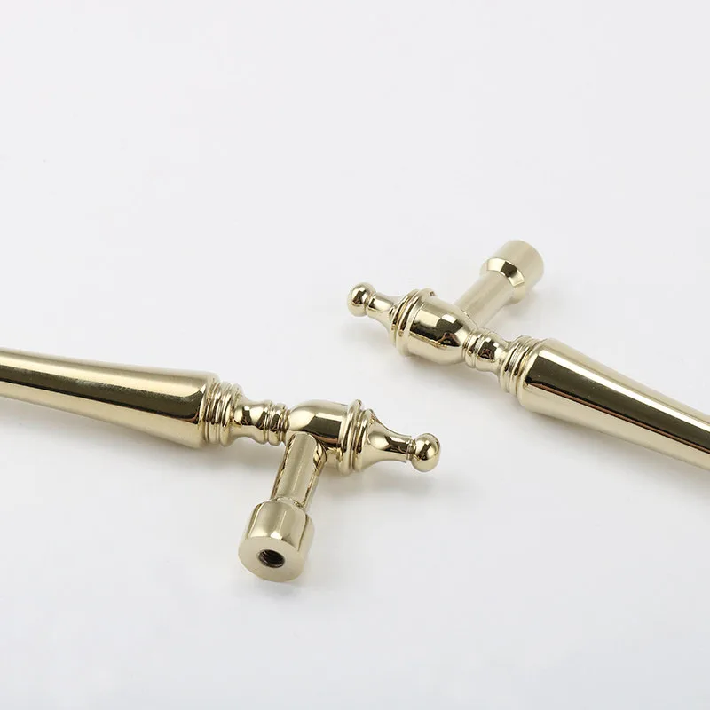Underside of gold cabinet handles showing screw holes