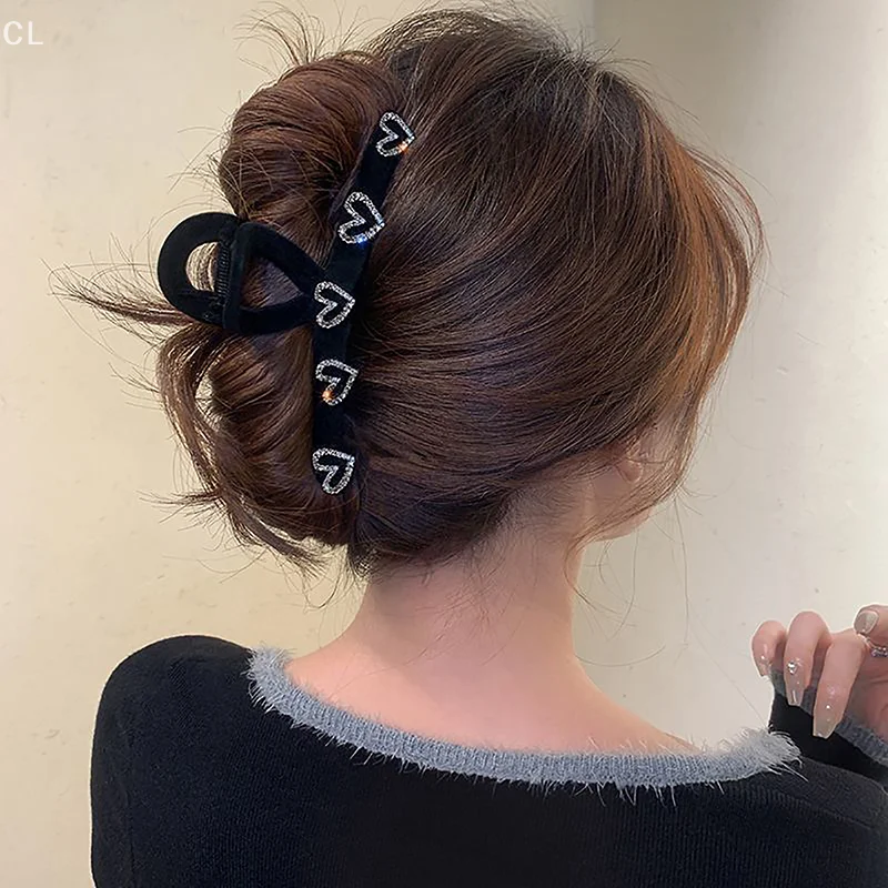 말꼬리 팬 스타일을 위한 라인스톤 디테일이 있는 절묘한 블랙 플로킹 헤어 클립.