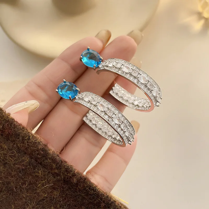 

Copper Arc Zircon Earrings - Metal Strips Blue Gem Inlaid Hollow Silver-Blue Fuzzy Background