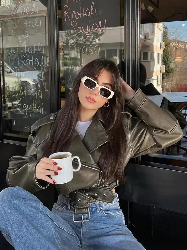 سترة قصيرة للسيدات كبيرة الحجم موديل 2025 من الجلد الصناعي الصناعي مع حزام ملابس الشارع الشهير معطف نسائي بسحاب ريترو موتو لراكبي الدراجات النارية ملابس خارجية