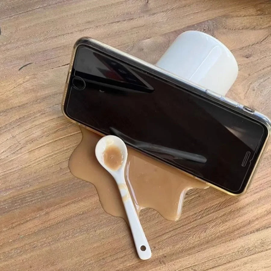 A spilled coffee spilled a novel and quirky desktop  decoration toy, a funny gift, a phone holder