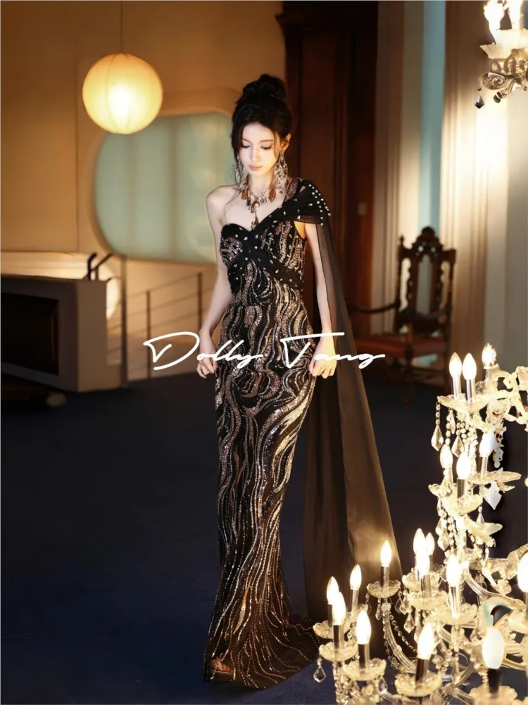 A luxurious black sequined dress with flowing ribbon design