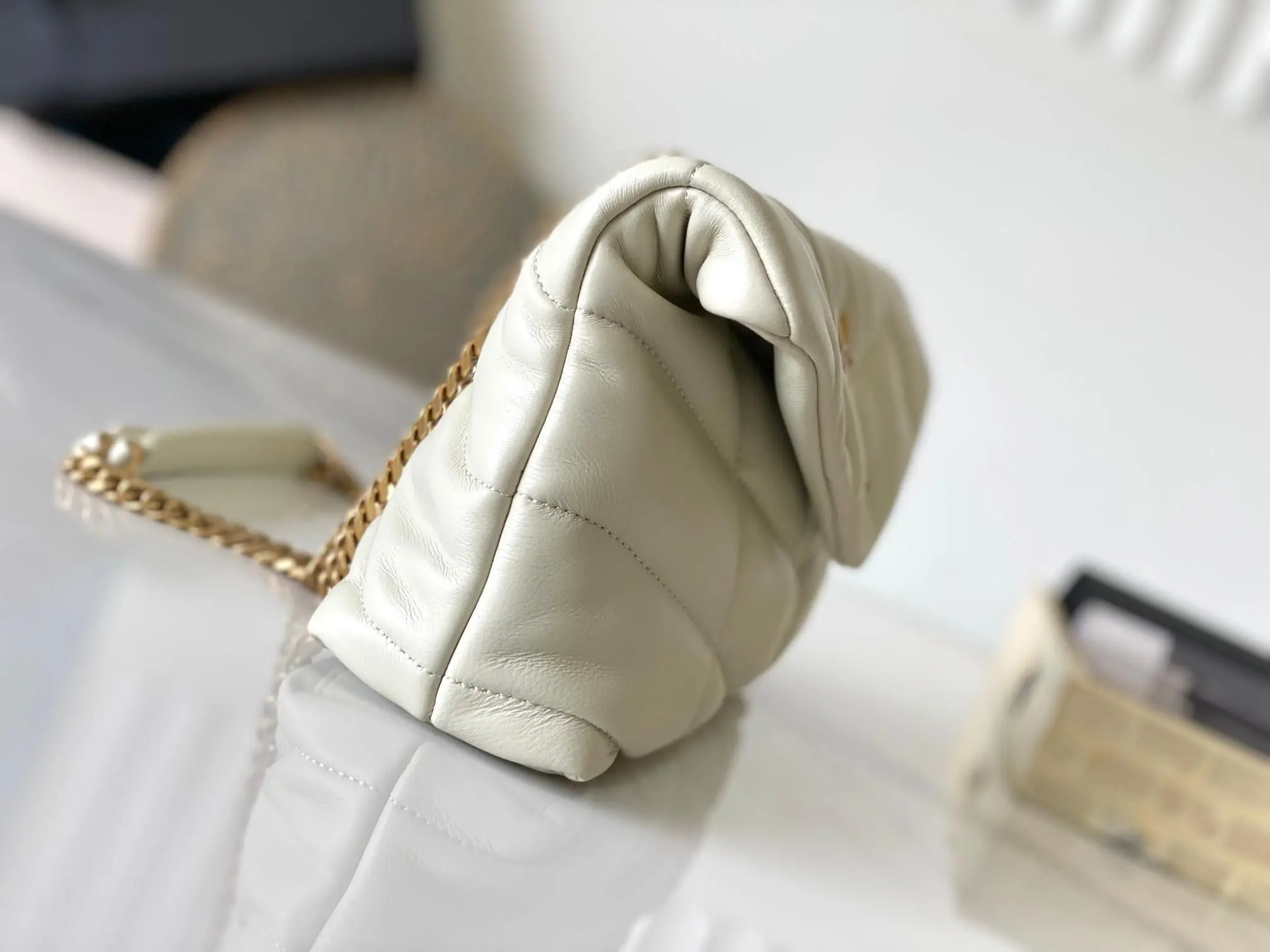 

Cream puffy quilted leather shoulder bag with oversized diamond stitching and gold chain.