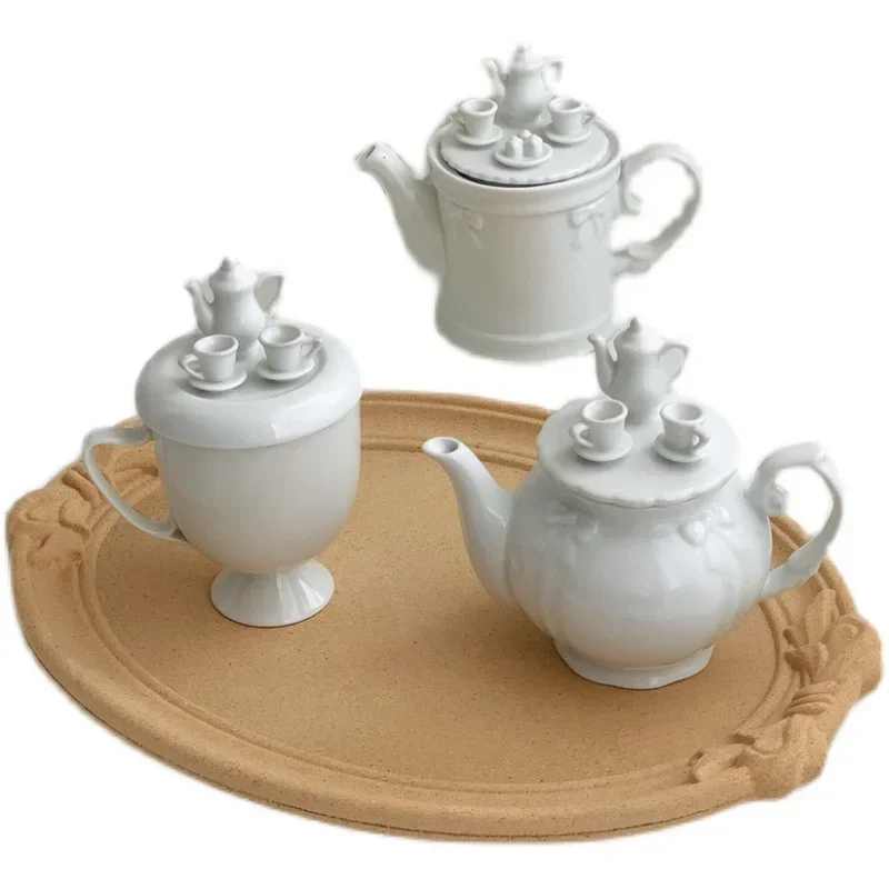 

The lid of the teapot exudes the flavor of afternoon tea, featuring a bow shaped ceramic teapot with a high foot lid, cup, and t