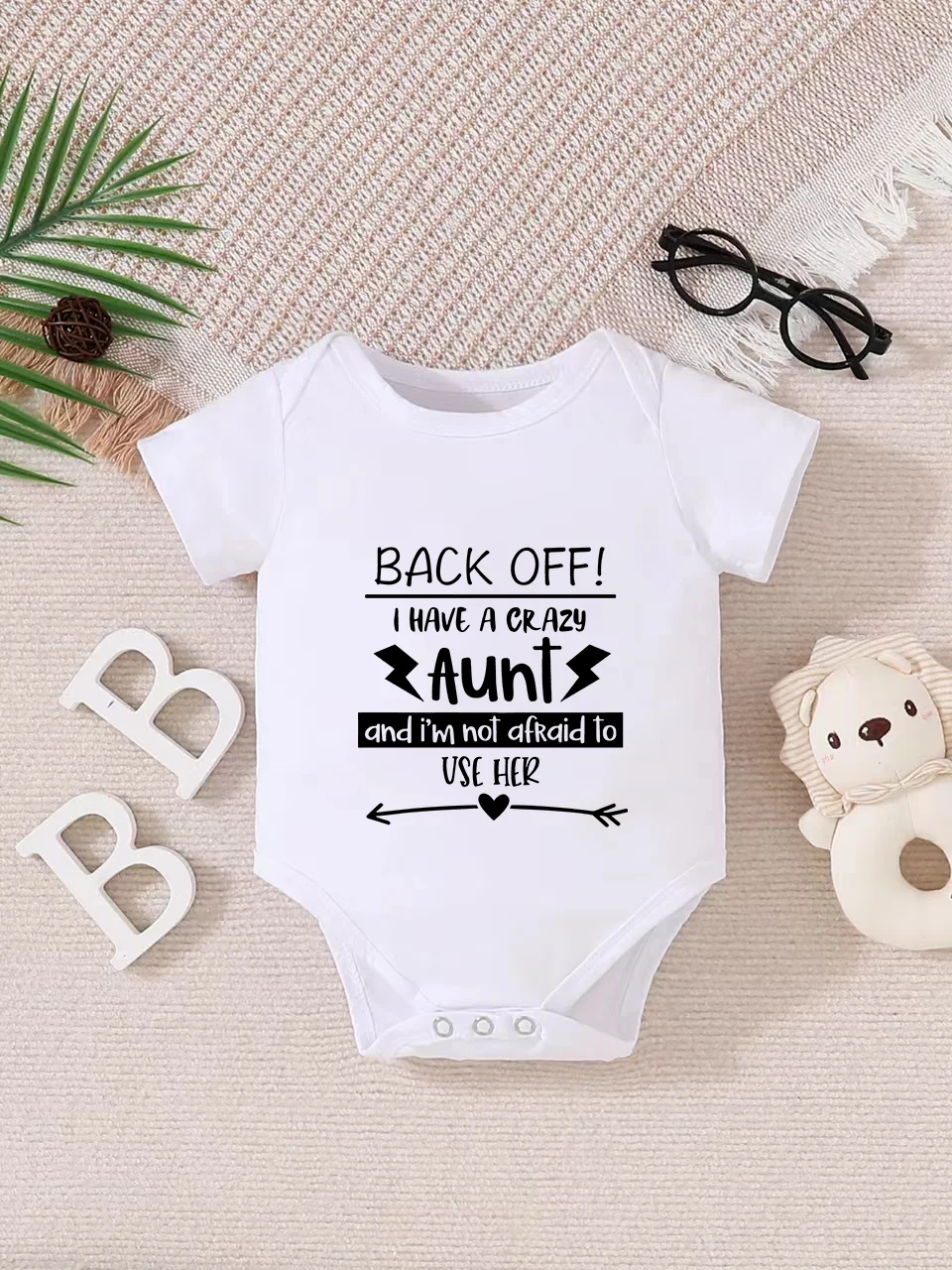 Playful letter-printed baby short-sleeve triangle bodysuit. Button closure for easy dressing, machine washable