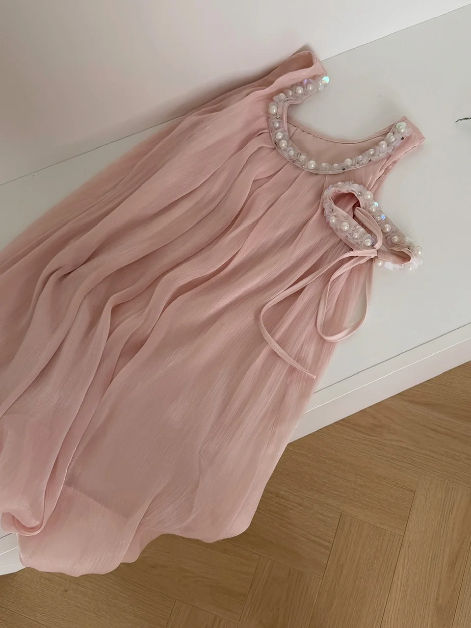 فستان نسائي صيفي فاخر بخيوط لامعة وزخارف ثقيلة، تنورة قصيرة بتصميم A-Line وخصر مرتفع، بلون وردي ناعم مع زخارف على شكل براعم ز...