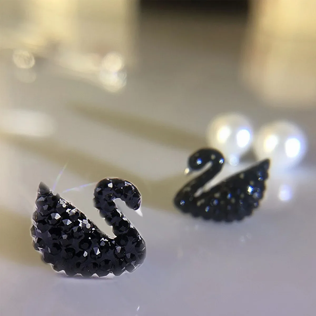 

MDL Moissanit. Style Niche Singapore Natural Shell Pearl Earplugs Gold-plated Tassel Black Swan Temperament Silver Pin Earrings