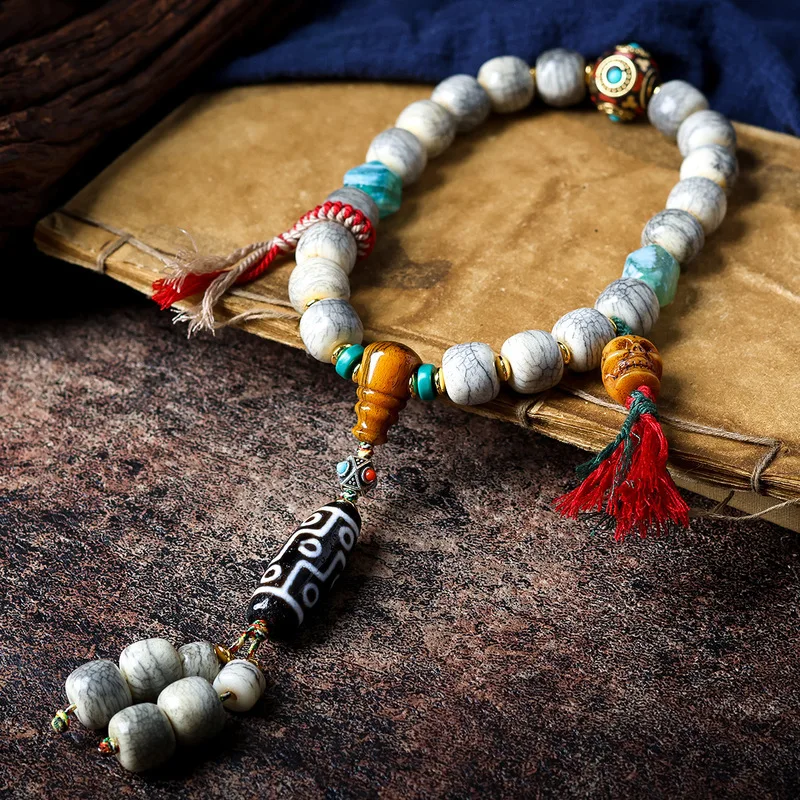 Tibetan-style crack-patterned yak bone hand-woven with nine-eye dzi used as prayer beads or rosary