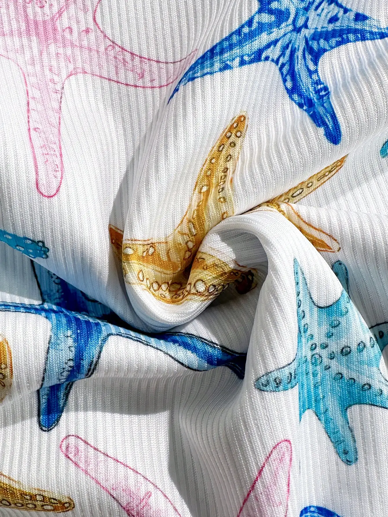 

Женский купальник-монокини с ребристой текстурой, принтом в виде морских звезд, на тонких бретелях и с завязками по бокам