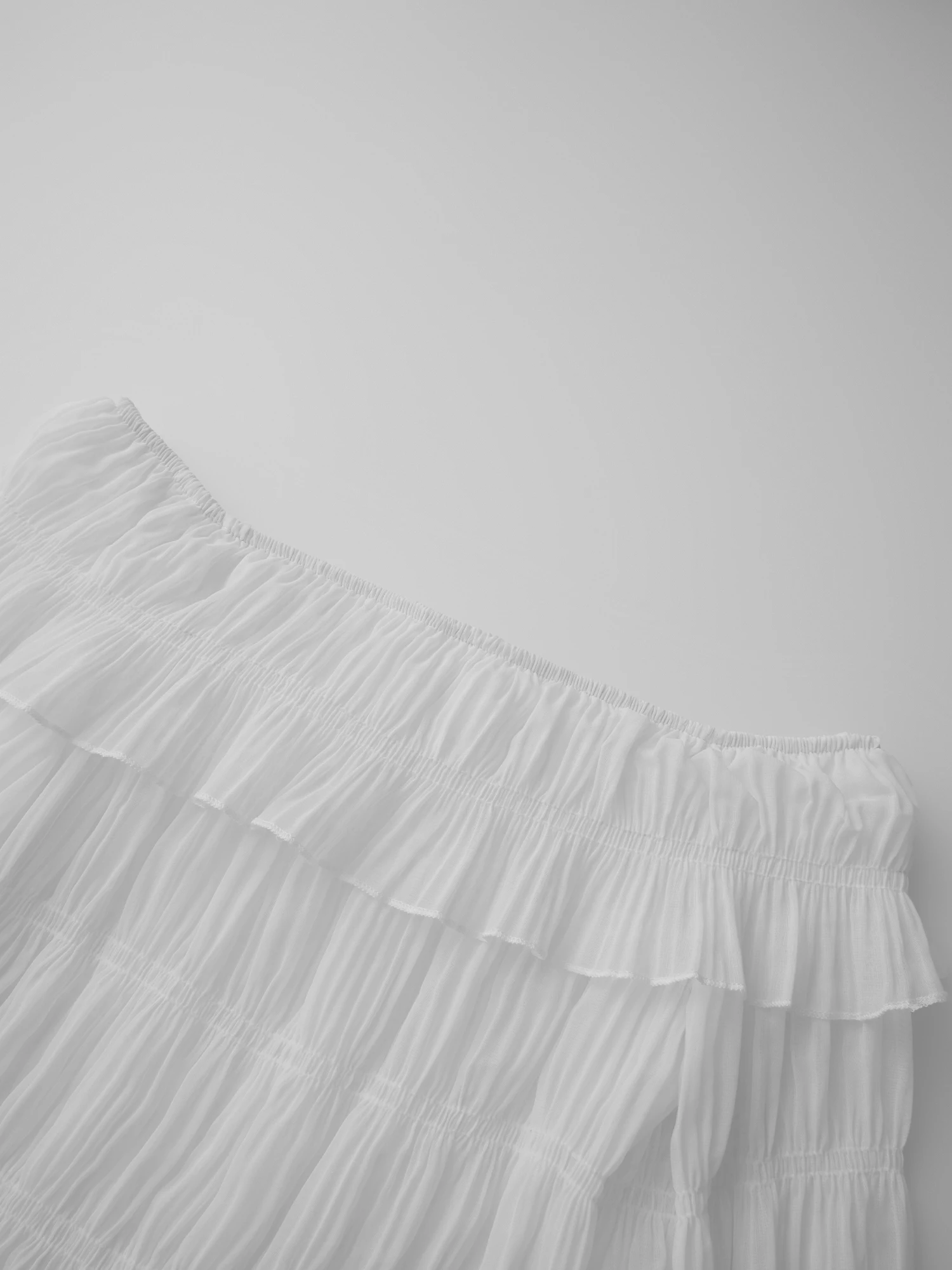 بلوزة أنيقة مزينة بالدانتيل مكشوفة الكتف بأكمام جرس وتفاصيل مطرزة بالزهور لفصلي الربيع والصيف