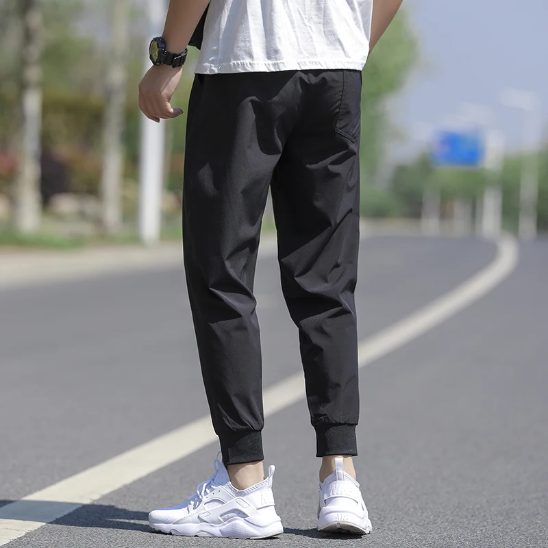 Wysokiej jakości nowa marka casualowe modne elastyczne spodnie dresowe z paskami, długie, ołówkowe, młodzieżowe, dopasowane, szybkoschnące spodnie męskie.