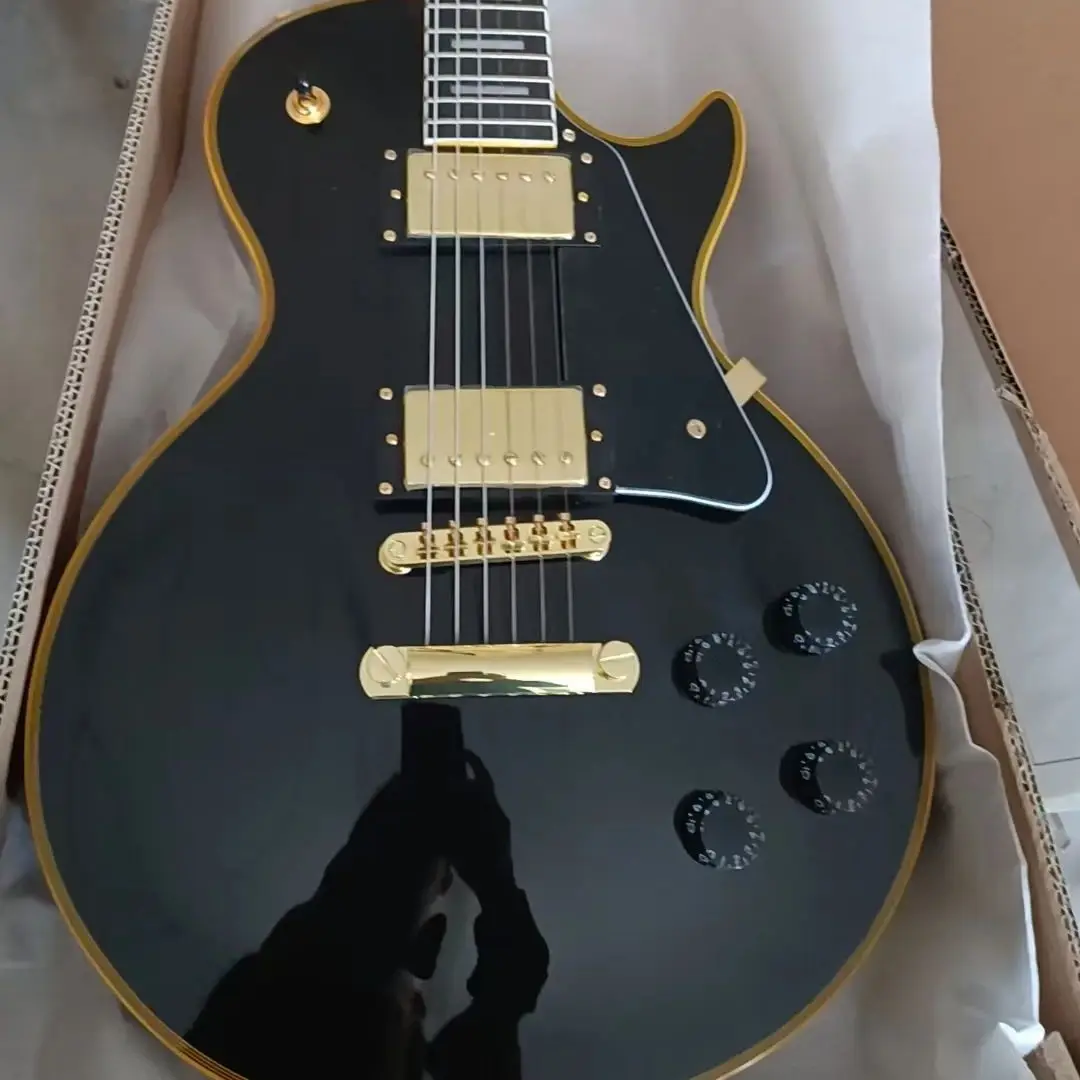 Guitarra eléctrica de caoba negra con accesorios dorados, puente de montaje de pastilla HH