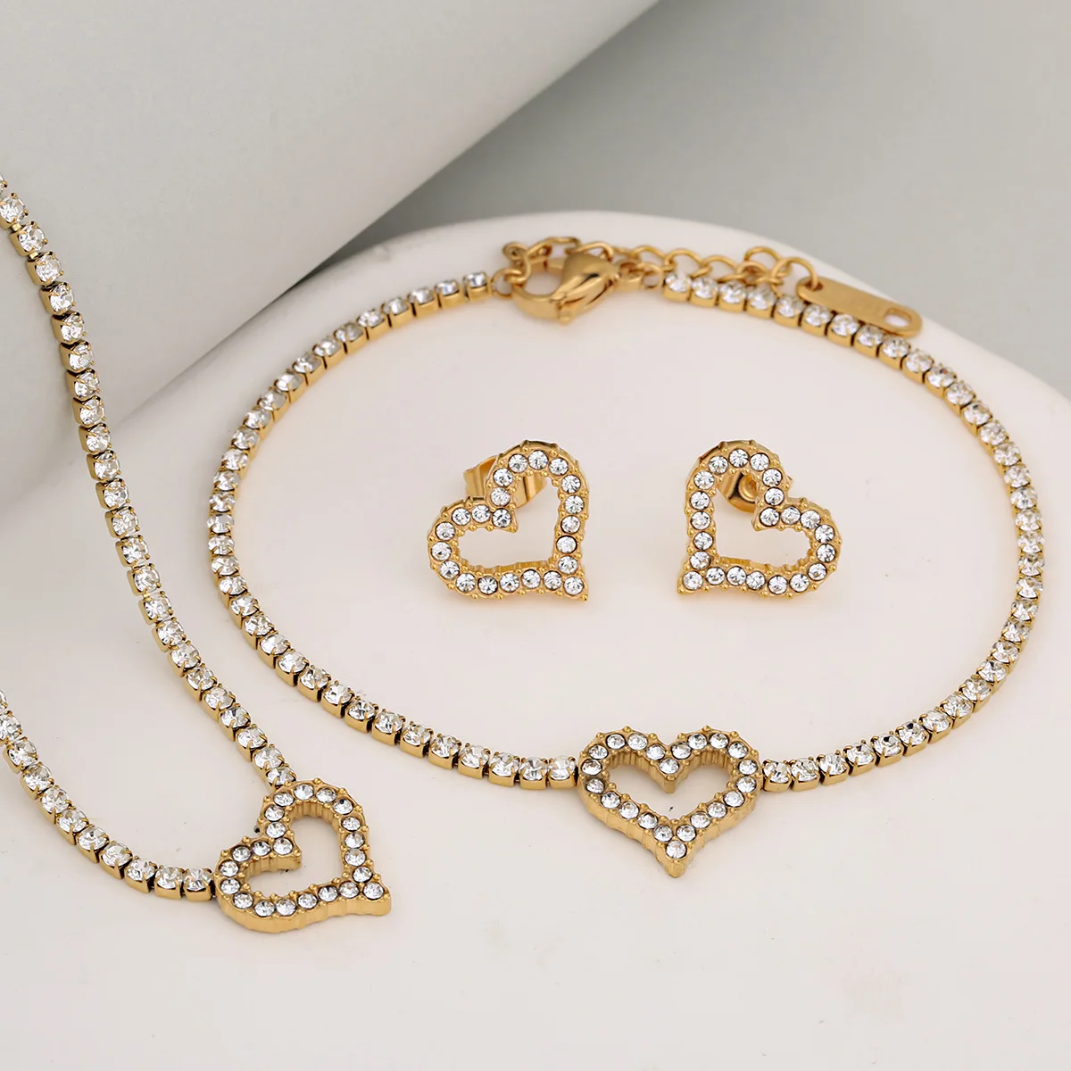 

Набор украшений для женщин: серьги, браслет и ожерелье из нержавеющей стали с полным покрытием из сверкающих бриллиантов в форме сердца.