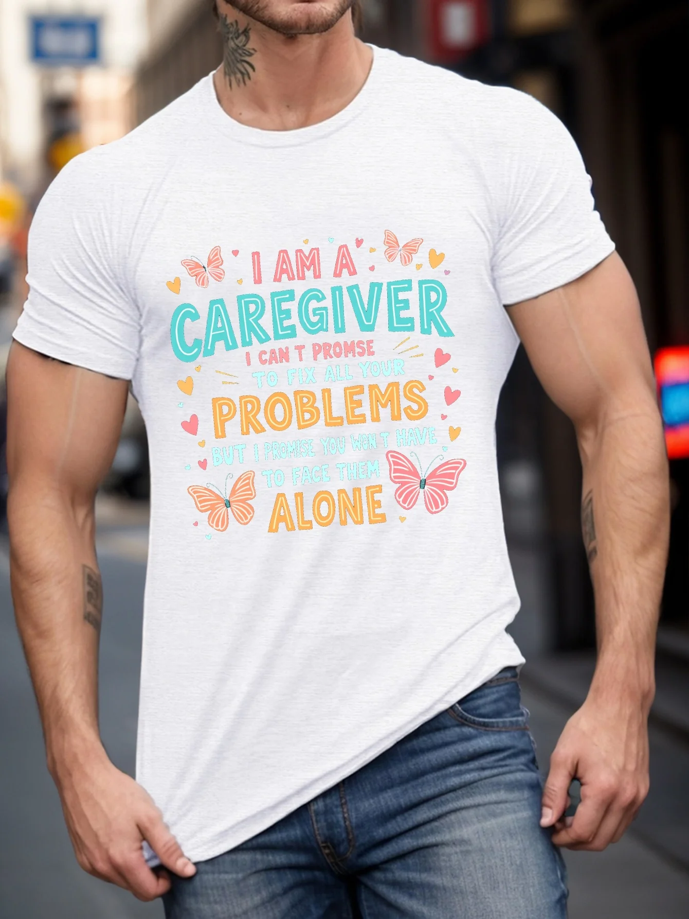 

Butterfly Men Wrinkle T-Shirt with the slogan "I'm the Caregiver", featuring colorful butterflies and heart-shaped designs
