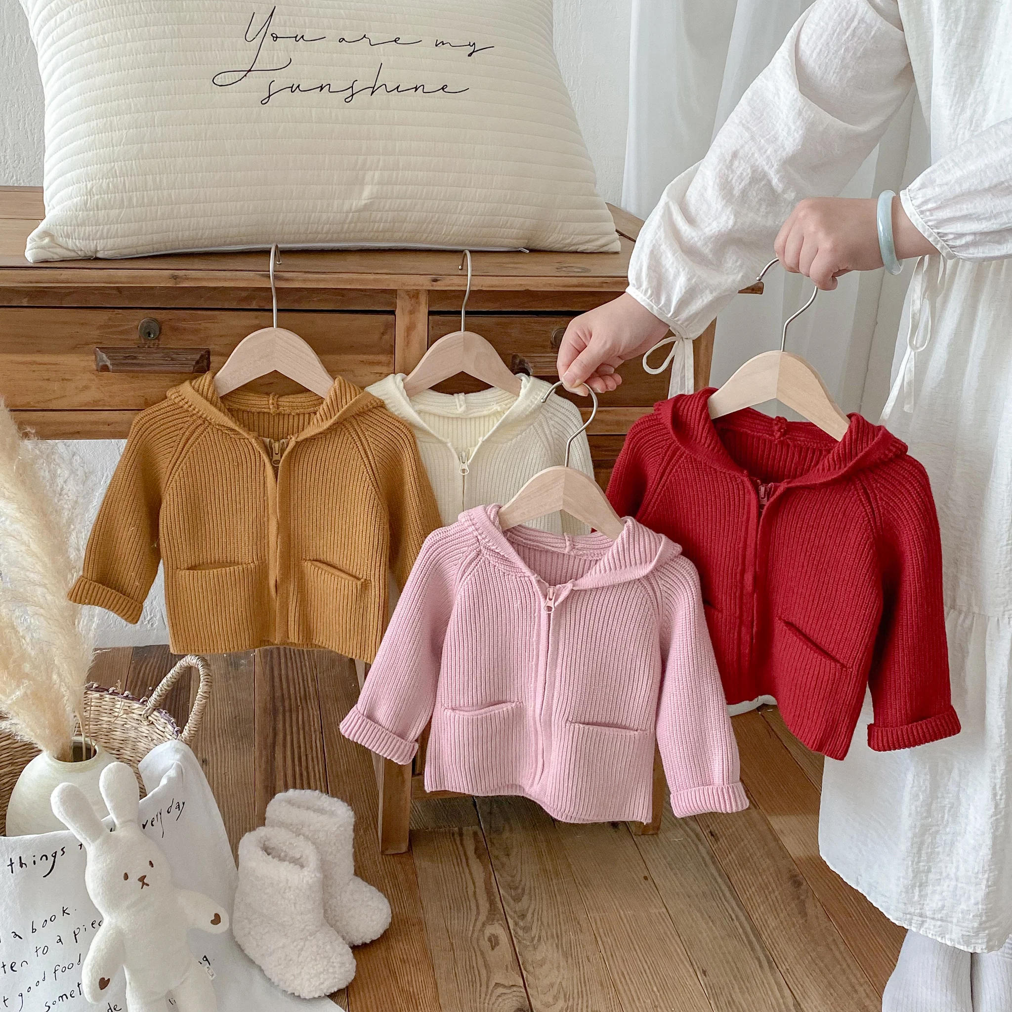 A solid-color hooded sweater jacket for girls is stylish, cute and warm in autumn and winter. A loose cardigan for infants and t