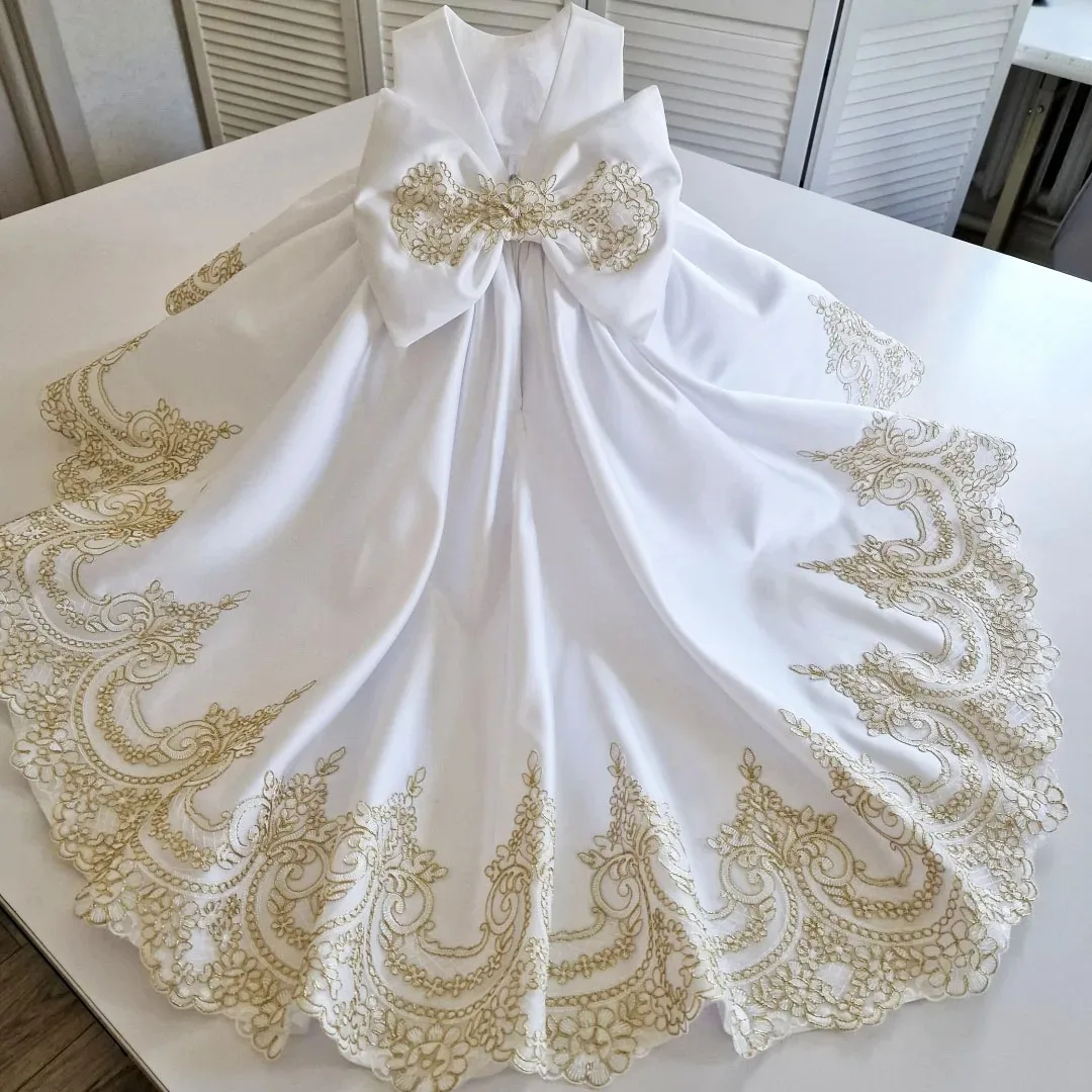 

Custom flower girl dress, white satin, gold appliqué, bow design, suitable for weddings, birthday parties, and communion ceremon