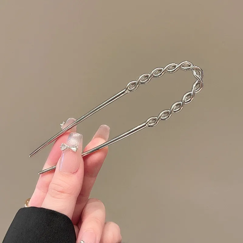 금속 참 장식의 꼬임 패턴과 매끄러운 교차로 엮인 U자형 브로치가 세련된 드레싱 스타일을 빛내며, 독특하면서도 고급스러운 느낌을 선사합니다.